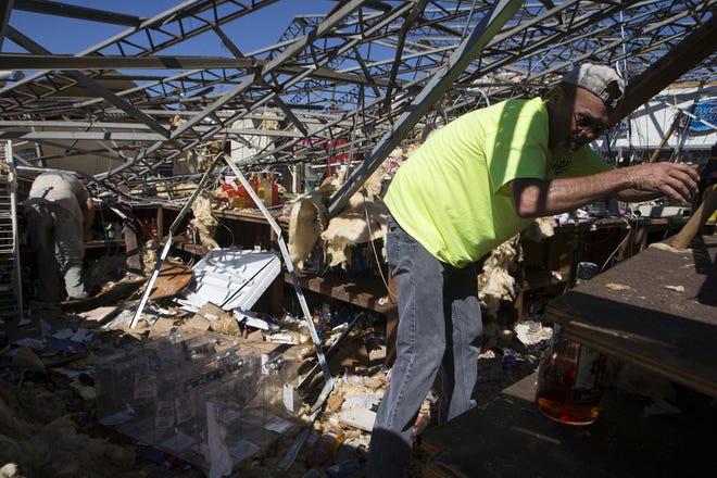 Ferrell Leah and Dewayne McGill help take the inventory Oct. 12, 2018, out of the Bottle Stopper in the Millville community in Panama City after Hurricane Michael. Both workers were concerned about the health of the owner and being able to reopen the liquor store. [JOSHUA BOUCHER/NEWS HERALD FILE]