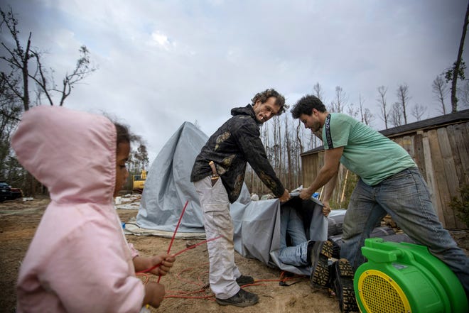 Jeff Dunn, left, and Lance Gomez help construct a dome shelter in Diahnn "Shelly" Summers' backyard for local residents left homeless from Hurricane Michael in Youngstown, Fla, Wednesday, Jan. 23, 2019. Summers and her husband, Sam, want to build some more permanent housing on the property for their "guests" but said they have run into regulatory roadblocks. [David Goldman/AP Photo]