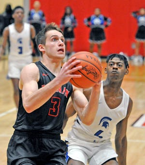 Rittman's Connor Stuart (left), who led all scorers with a game-high 20 points, goes up for a layup off a fast break in front of Richmond Heights' Curtis Houston II during their Div. IV district semifinal Monday at Norton High. The Indians' season ended with a 70-54 loss to the top-seeded Spartans.