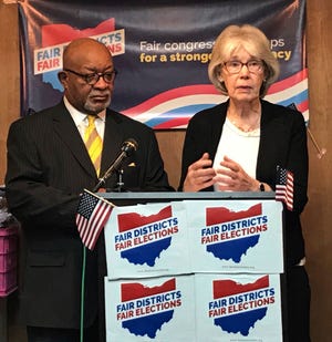 File-In this Jan. 22, 2018, file photo, fair Congressional Districts for Ohio members Ann Henkener, right, of the League of Women Voters, and Sam Gresham, of Common Cause Ohio, react to a competing redistricting proposal by state Rep. Matt Huffman (R-Lima) during a news conference in Columbus, Ohio. Voting rights groups that charge that Ohioâ€™s congressional map was unfairly manipulated by state Republicans will have their say in federal court. The trial for a lawsuit filed last year is scheduled to open Monday, March 4, 2019, in Cincinnati. The suit challenges the district maps in effect through 2020 for "an unconstitutional partisan gerrymander" that violates voters' rights. (AP Photo/Julie Carr Smyth, File)