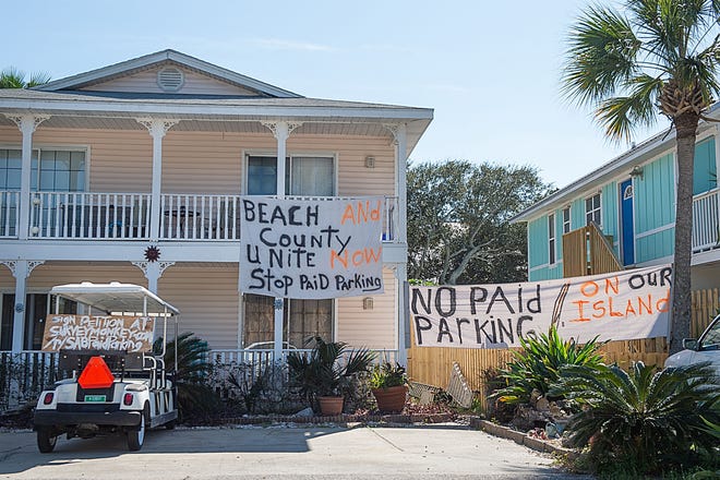 Signs at a property on A Street in St. Augustine Beach protest the city's proposal to charge for public parking. [PETER WILLOTT/THE RECORD]