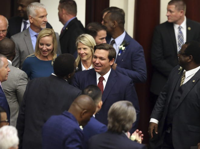 Gov. Ron Desantis, center, is welcomed to a joint session of the legislature for his state of the state address Tuesday, March 5, 2019, in Tallahassee, Fla. (AP Photo/Steve Cannon)