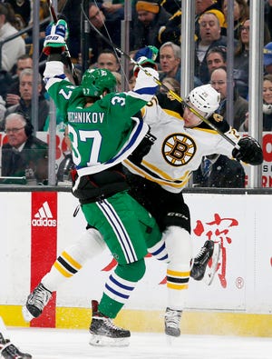 Carolina Hurricanes right wing Andrei Svechnikov (37) and Boston Bruins defenseman Brandon Carlo (25) collide along the boards during the first period of an NHL hockey game, Tuesday, March 5, 2019, in Boston. (AP Photo/Mary Schwalm)