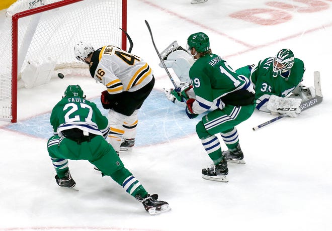 Boston Bruins center David Krejci (46) scores the game-winning goal past Carolina Hurricanes goaltender Curtis McElhinney (35) and defenders Justin Faulk (27) and Dougie Hamilton (19) during extra time of an NHL hockey game, Tuesday, March 5, 2019, in Boston. (AP Photo/Mary Schwalm)