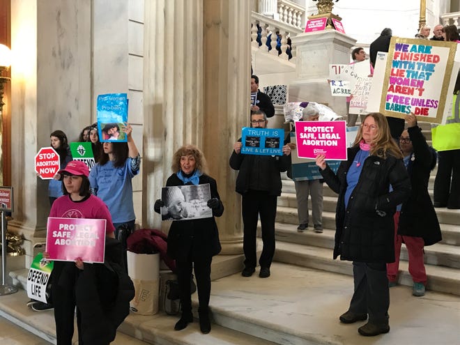 People on both sides of the abortion issue gather at the State House rotunda on Tuesday before a House hearing on a bill that would guarantee the right to abortion in Rhode Island law. [The Providence Journal / Bob Breidenbach]