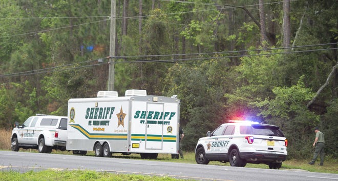 St. Johns County Sheriff's deputies investigate a suspected methamphetamine lab discovered in the woods off U.S. 1, south of St. Augustine, on Saturday. [PETER WILLOTT/THE RECORD]