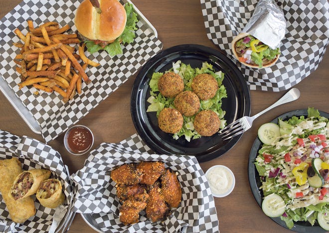 Clockwise from top left: S.O.B. burger and fries, Falafel, Chicken Shawarma sandwich, Greek salad with chicken, Garlic Parmesan Chicken Wings and Ghost Pepper Mac and Smoked Brisket Eggrolls