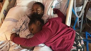 Ja'Ryan Wright lays in his hospital bed with sister Nylah Wright hugging him after a December wreck critically injured.

[Amy Wright/Special to The Gazette]