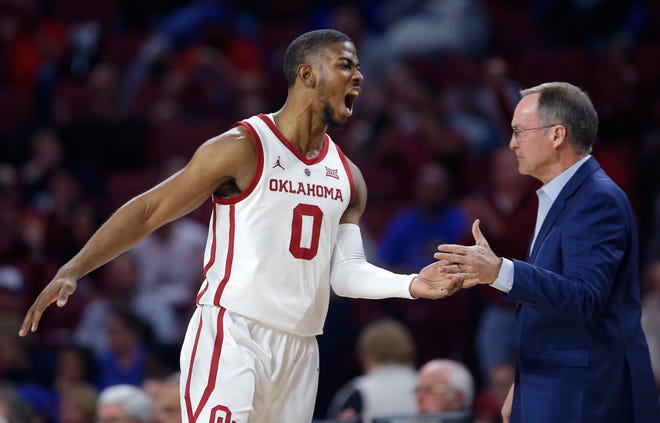 Oklahoma's Christian James (0) celebrates a 3-point basket with head coach Lon Kruger during the men's college basketball game between the University of Oklahoma and Kansas at the Lloyd Noble Center in Norman, Okla., Tuesday, March 5, 2019. Photo by Sarah Phipps, The Oklahoman