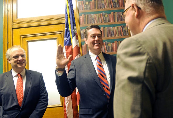 City Manager Ed Augustus is sworn in by City Clerk David Rushford, right, in 2014, joined by Mayor Joe Petty. [T&G File Photo]