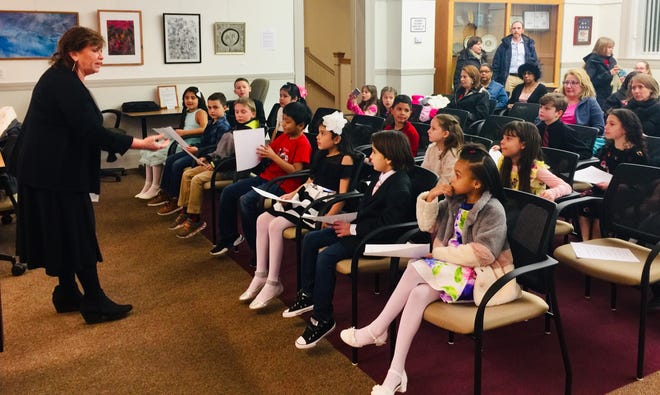 Kathy Duran delivers last-minute instructions to second-graders from Hyannis West. The students opened the March 6 School Committee meeting by reading their essays on "How can I make a difference?" Inspired by their studies of Dr. Martin Luther King, Jr., the students dedicated their work in memory of Barnstable's Joe DaLuz. [BP PHOTO BY BRONWEN HOWELLS WALSH]