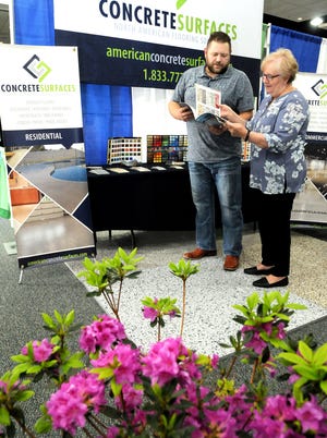 Jason Miller, owner of Concrete Surfaces, Cambridge, talks with Cambridge Area Chamber of Commerce President Jo Sexton about the types of flooring he offers at his booth at this year's Home, Garden and Business Expo at the Pritchard Laughlin Civic Center. The event begins today and continues through Sunday. Hours are today until 8 p.m.; Saturday from 11 a.m. until 7 p.m.; Sunday from noon until 4 p.m. Admission is $3; $2 seniors; $7 family.