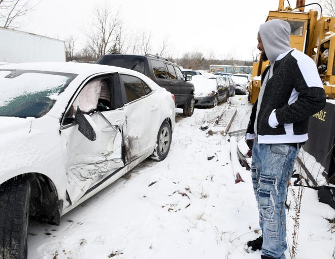 Ronald Goodwin, of Cleveland, looks at the damage to the driver side door of his 2014 Chevy Malibu, where he was in Tuesday’s Route 8 pile-up. Goodwin was collecting personal items from the car which was at a second Interstate Towing overflow location.