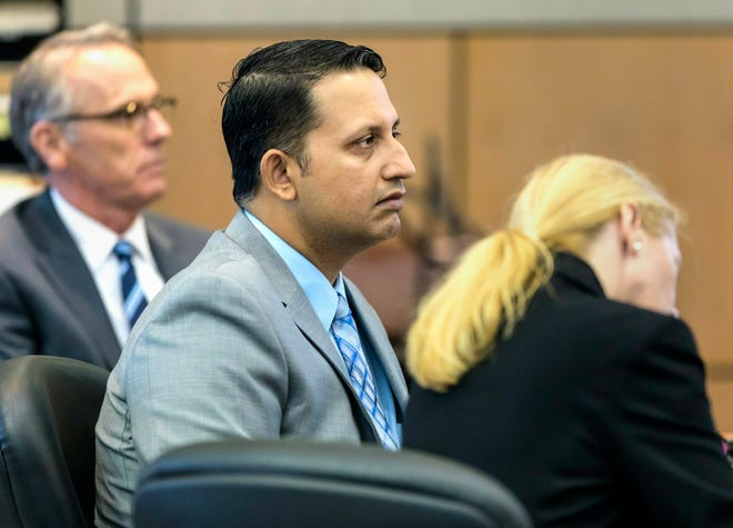 Nouman Raja sits between defense attorney Scott Richardson, left, and paralegal Debi Stratton as attorney Richard Lubin gives his closing arguments in Raja's trial, Wednesday, March 6, 2019 in West Palm Beach, Fla.  Raja, a former Palm Beach Gardens police officer, is charged with the fatal 2015 shooting of stranded motorist Corey Jones. (Lannis Waters/Palm Beach Post via AP, Pool)
