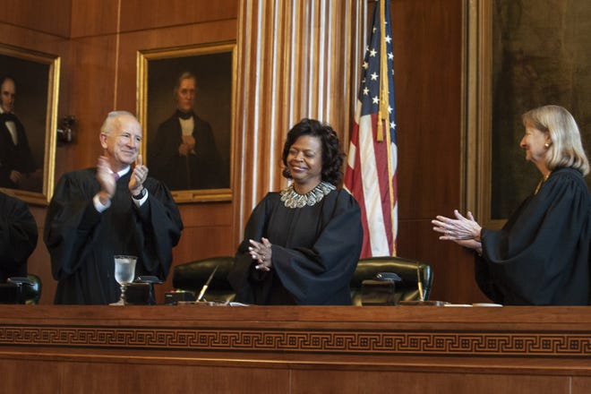 Chief Justice Cheri Beasley of the N.C. Supreme Court stands with her family as she takes the oath of office during her investiture ceremony in Raleigh on Thursday, March 7, 2019. [Paul Woolverton/The Fayetteville Observer]