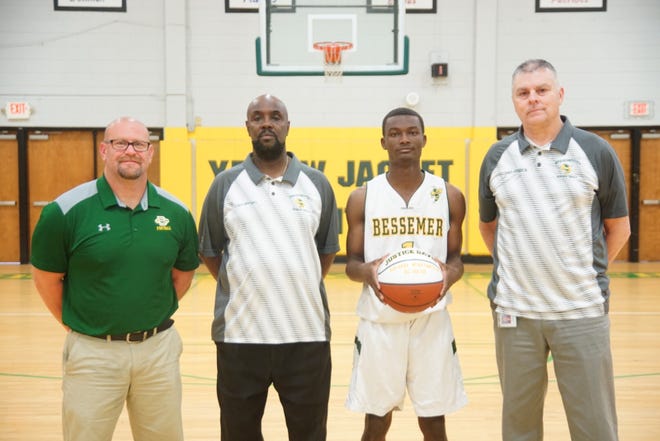 REACHING A MILESTONE: Bessemer City High junior guard Justice Davis scored his 1,000th point at Lincoln Charter. Pictured from left are Athletic Director Larry Boone, head coach Danny McDowell, Justice Davis holding the game ball and assistant coach Billy James. [SPECIAL TO THE GAZETTE]
