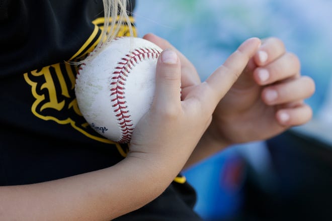 A young fan holds onto a baseball she got from Pittsburgh Pirates first baseman Francisco Cervelli during the fourth inning of Friday's spring training game between the Pirates and Blue Jays at LECOM Park in Bradenton. [THE ASSOCIATED PRESS / CHRIS O'MEARA]