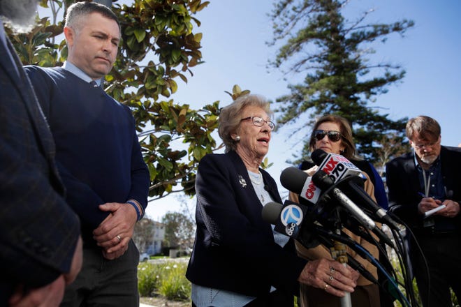 Joined by Newport Harbor High School Principal Sean Boulton, left, Eva Schloss, the stepsister of Anne Frank and a Holocaust survivor, talks to reporters during a news conference Thursday, March 7, 2019, in Newport Beach, Calif. Schloss met Thursday with Southern California high school students who were photographed giving Nazi salutes around a swastika formed by drinking cups at a party. Schloss said the students apologized for their behavior and indicated they didn't realize what it really meant. (AP Photo/Jae C. Hong)
