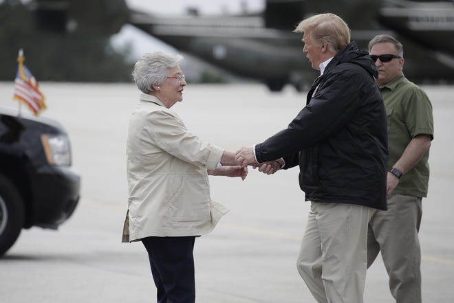 President Donald Trump is greeted by Alabama Gov. Kay Ivey on Trump's arrival Friday in Auburn, Ala., en route to Lee County, where tornados killed 23 people. [AP Photo/Carolyn Kaster]