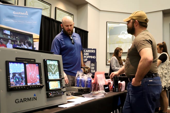 Garmin Technical Supervisor David Koenig, left, talks with UAFS student Richard Schafer about the opportunities available at Garmin on Thursday, March 7, 2019, during the school's career fair in the Reynolds Room. More than 50 employers were on hand to accept resumes for full-time, part-time and internships during the event. [JAMIE MITCHELL/TIMES RECORD]
