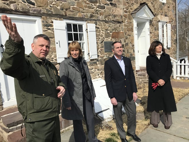 From the Thompson-Neely House in Washington Crossing Historic Park, state park Manager George Calaba, left, gestures to Bowman's Tower in talking about its infrastructure needs, as Cindy Adams Dunn, secretary of the Pennsylvania Department of Conservation and Natural Resources, state Sen. Steve Santarsiero, D-10, of Lower Makefield, and state Rep. Wendi Thomas, R-178, of Northampton, look on, Friday. [THOMAS FRIESTAD / STAFF]