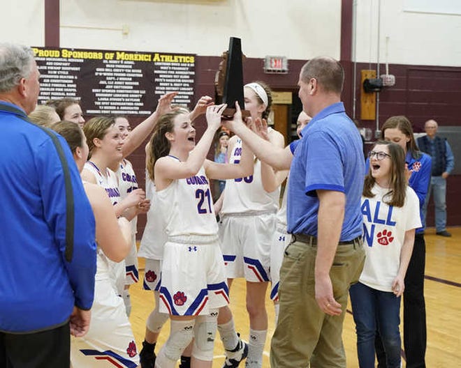 Lenawee Christian girls basketball celebrates with the Division 4 district trophy Friday at Morenci