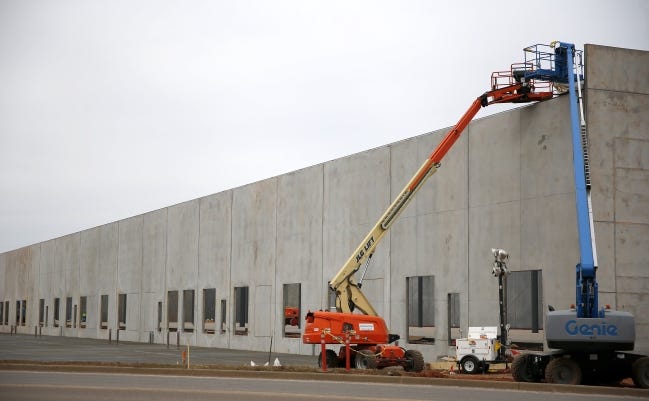 A construction crew works on erecting a warehouse on SW 44.