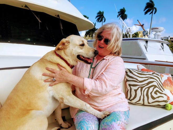 Sharon McGinley and Hinckley relax on their boat. [Photo by Paul Noble]