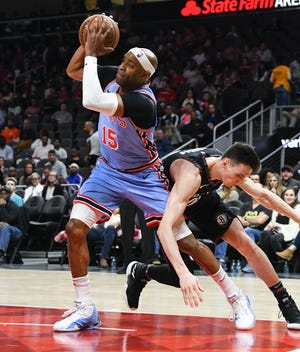 Atlanta Hawks forward Vince Carter (15) grabs a loose ball from going out of bounds as Brooklyn Nets forward Rodions Kurucs goes for it Saturday in Atlanta. [JOHN AMIS/THE ASSOCIATED PRESS]
