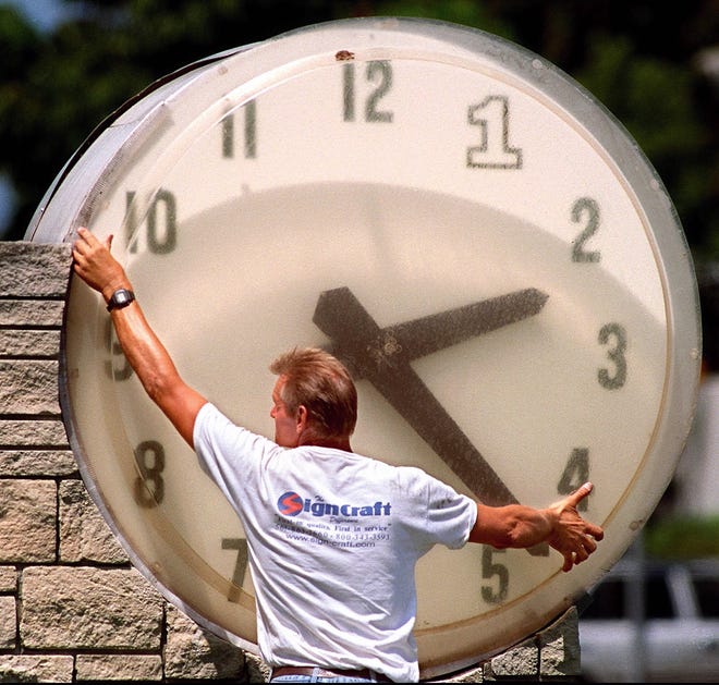 WEST PALM BEACH; 4-7-99: Joe Roskey (cq) of Sign Craft (cq), of Riviera Beach, works on the outdoor clock at the First Bank of Florida, at the corner of Olive Avenue and Southern Blvd Wednesday afternoon. Roskey had corrected the time on the clock, which was off because of the switch to daylight savings time. The bank will become Republic Security Bank (cq) April 19 (cq). Staff Photo by Lannis Waters-TO RUN 4-8-99- 2 B MSL- B-W- SLUG: CLOCKCLO- 35 W X 5.50 D- LGH- SENT TO DTI 8:45P- B-W