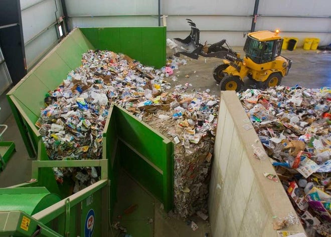 A loader moves items to be recycled onto the feed line at the materials recovery facility Waste Management maintains at 7351 N.W. US-75 highway. [2013 file photo/The Capital-Journal]