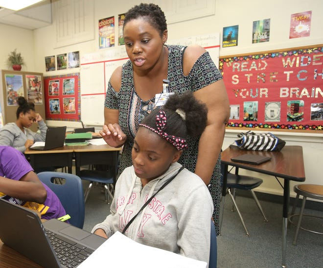 Teacher Jamila McGinnis works with Amari Cobb on Monday at Osceola Middle School. Students were practicing for the eighth-grade FSA writing test. This year, many state tests will be administered later in the school year than before. [Bruce Ackerman/Staff photographer]