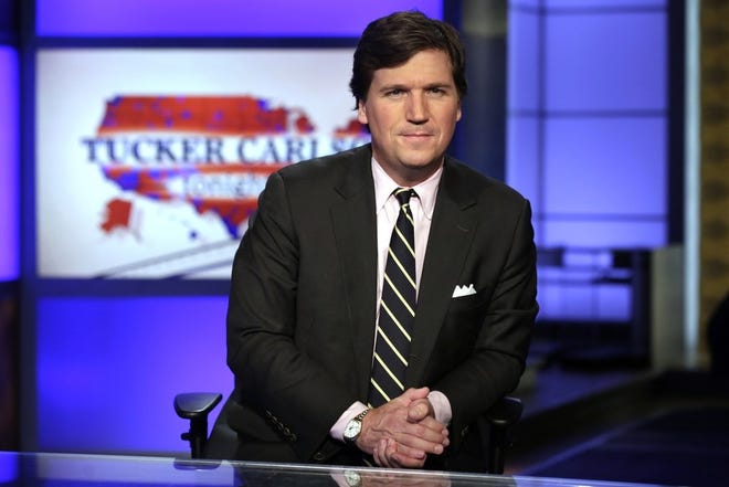 In this March 2, 2017, file photo, Tucker Carlson, host of "Tucker Carlson Tonight," poses for photos in a Fox News Channel studio in New York. Washington police are investigating a protest outside the home of Carlson as a possible hate crime. According to a police report, a group of demonstrators gathered outside Carlson's Northwest Washington home Wednesday night, Nov. 7, 2018. A video posted on social media but later removed shows people standing outside a darkened home chanting "Tucker Carlson we will fight/We know where you sleep at night." (AP Photo/Richard Drew, File)