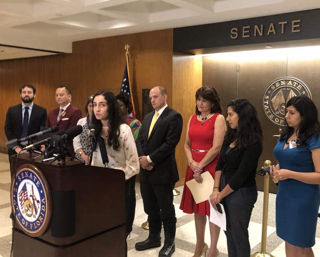 Florida State University student Nataly Chalco Lopez, at podium, a 19-year-old immigrant from Peru, said her parents did not drop her off at college because of fears they might be pulled over during the drive from Broward County and deported. [Herald-Tribune staff photo / Zac Anderson]