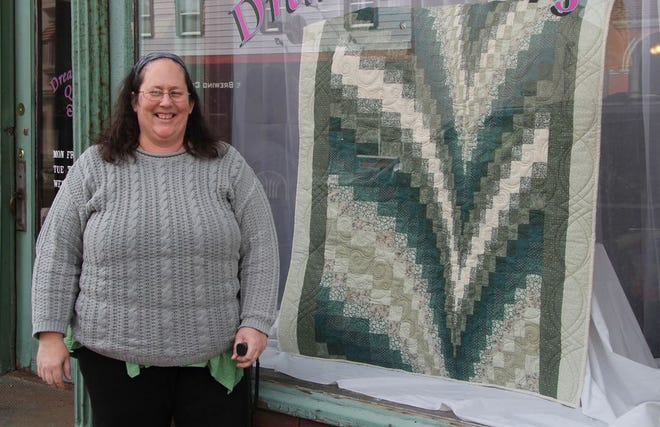Dee DeSadier, co-owner of Dreamcatchers, stands with the quilt she and co-owner Ronda Cunic made that will be raffled off following the Taste of the Village.