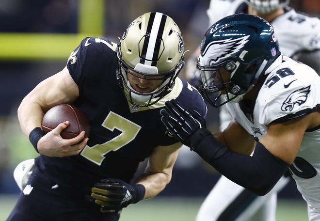 Eagles linebacker Jordan Hicks tackles Saints quarterback Taysom Hill during the NFC divisional playoff game. [BUTCH DILL / THE ASSOCIATED PRESS]