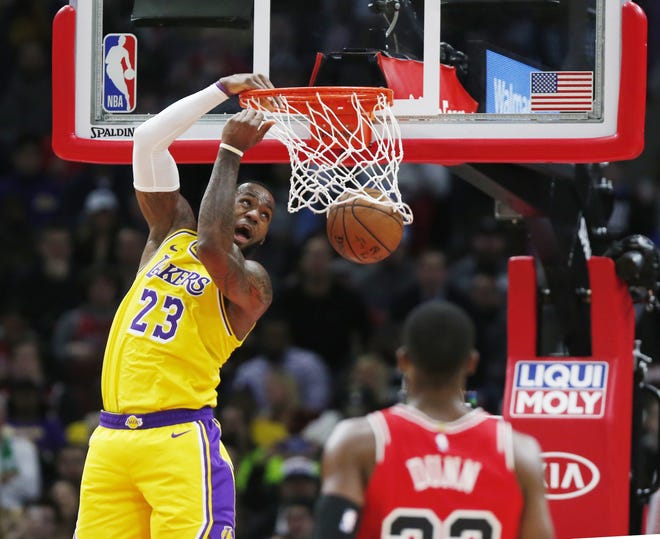 Los Angeles Lakers forward LeBron James (23) dunks in front of Chicago Bulls guard Kris Dunn during the second half Tuesday, March 12, 2019, in Chicago. [NUCCIO DINUZZO/THE ASSOCIATED PRESS]