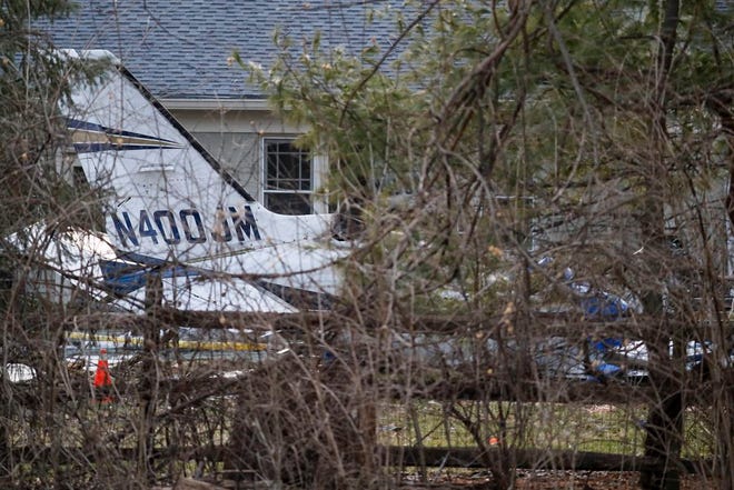 Wreckage is strewn across the backyard of a home at the scene of a plane crash on Rollymeade Ave., Tuesday in Madeira, Ohio. Authorities say a small plane has crashed into a house in a suburban Cincinnati community, killing the pilot. [John Minchillo/The Associated Press]