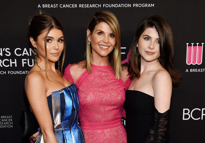 In this Feb. 28, 2019 file photo, actress Lori Loughlin, center, poses with daughters Olivia Jade Giannulli, left, and Isabella Rose Giannulli at the 2019 "An Unforgettable Evening" in Beverly Hills, Calif. Loughlin and her husband Mossimo Giannulli were charged along with nearly 50 other people Tuesday in a scheme in which wealthy parents bribed college coaches and other insiders to get their children into some of the most elite schools in the country, federal prosecutors said. (Photo by Chris Pizzello/Invision/AP, File)