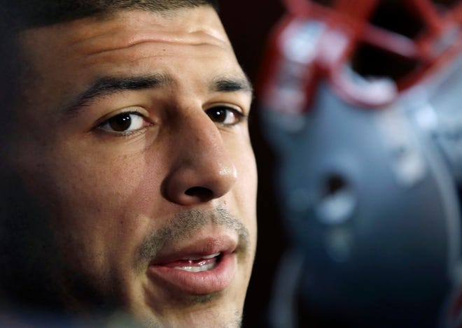 FILE - In this Sept. 5, 2012 file photo, New England Patriots tight end Aaron Hernandez speaks in the locker room at Gillette Stadium in Foxborough, Mass. Massachusetts' highest court on Wednesday, March 13, 2019, reinstated Hernandez's murder conviction, scrapping a legal principle that had erased it after he killed himself in prison in April 2017. Hernandez had been found guilty in 2015 of killing semi-professional football player Odin Lloyd. Two years later, the 27-year-old was found dead in his prison cell days after being acquitted of most charges in a separate double-murder case. (AP Photo/Elise Amendola, File)