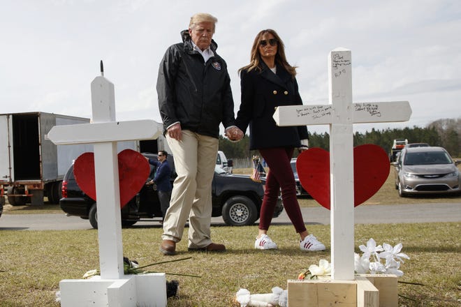 President Donald Trump and First Lady Melania Trump tour areas where tornados killed 23 people in Lee County, Ala. Trump is claiming that photos of his wife were altered to make it appear that a look-alike accompanied him to Alabama last week. [AP / Carolyn Kaster]