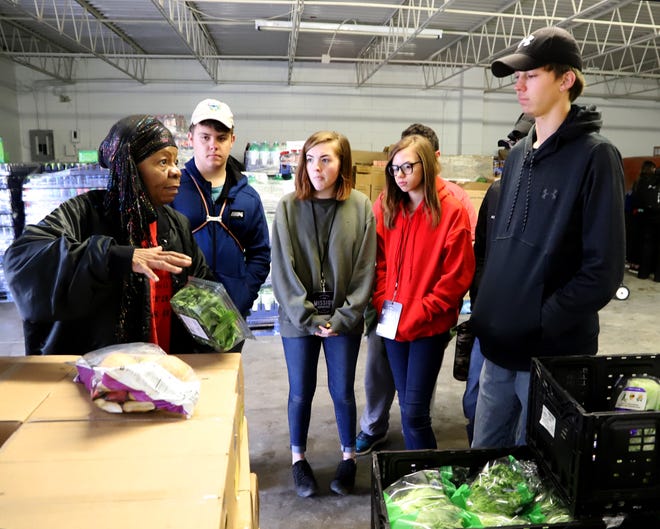 Charolette Tidwell, left, works with Youth With A Mission Ozarks volunteers to bag groceries at the Antioch for Youth & Family warehouse, 1420 N. 32nd St., on Tuesday, March 12, 2019. The 26 students from College Heights Christian School in Joplin, Missouri, will be in Fort Smith through Thursday to work with the Antioch organization sorting, packing and delivering food to those in need from the area. Antioch provides food assistance to as many as 12,000 people in the Fort Smith area. Food help is given at its pantry, through mobile pantry to veterans and select low-income senior living locations and the Antioch in Schools program. [JAMIE MITCHELL/TIMES RECORD]