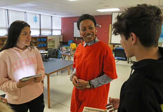 Kiara Butler, center, cofounder of Diversity Talks, chats with students Darisel Velez and Victor Anava before a recent program held at Calcutt Middle School, in Central Falls. Velez, 14, a freshman at Central Falls High School, is a facilitator for conversations on diversity and inclusion. [The Providence Journal / Steve Szydlowski]