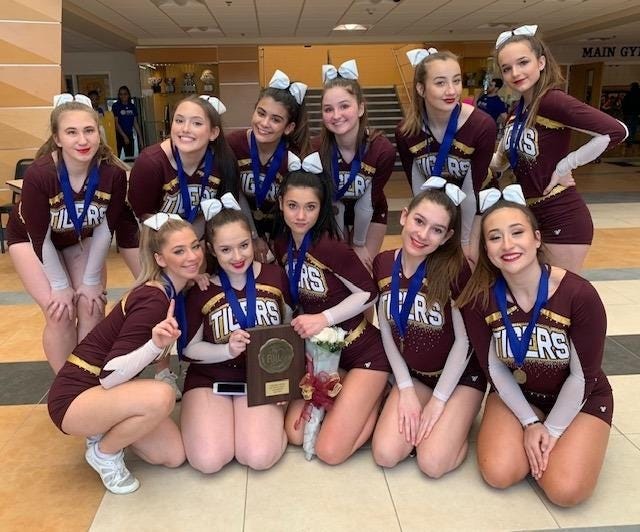 Members of the Tiverton cheerleading team pose with their Small Schools Division championship trophy on Saturday after the state meet on the Johnson & Wales University campus. [KRISTEN McDERMOTT PHOTO]