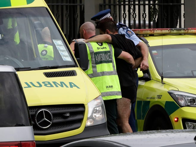 Police and ambulance staff help a wounded man from outside a mosque in central Christchurch, New Zealand, Friday, March 15, 2019. A witness says many people have been killed in a mass shooting at a mosque in the New Zealand city of Christchurch. (AP Photo/Mark Baker)