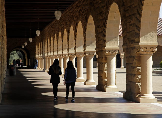 Students walk on the Stanford University campus Thursday, March 14, 2019, in Santa Clara, Calif. In the first lawsuit to come out of the college bribery scandal, several students are suing Yale, Georgetown, Stanford and other schools involved in the case, saying they and others were denied a fair shot at admission. The plaintiffs brought the class-action complaint Wednesday, March 13, 2019, in federal court in San Francisco on behalf of themselves and other applicants and asked for unspecified damages. (AP Photo/Ben Margot)