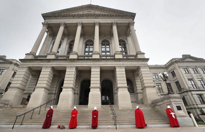 Georgia members of the Handmaid Coalition protest the passage of HB 481 outside the Capitol, Friday, March 8, 2019, in Atlanta. Now that the House has passed HB 481, the Senate is now tasked with tackling legislation that would ban most abortions after 6 weeks. The House approved the legislation late Thursday and advocates on both sides of the issues have already begun pushing senators to vote their way. (Bob Andres/Atlanta Journal-Constitution via AP)