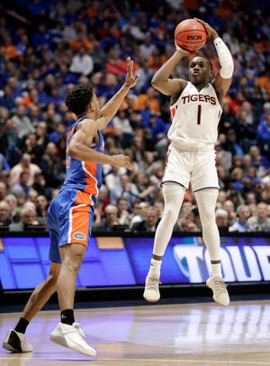 Auburn's Jared Harper (1) makes a 3-point shot against Florida's Jalen Hudson in the closing seconds Saturday in Nashville, Tennessee. [Associated Press/Mark Humphrey]