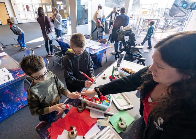 Brothers Noah Resner, 6, and Will Resner, 10, build model rockets out of paper with the help of Space Science Educator Michelle Snider at the Cosmosphere, Friday, March 15, 2019. [Jesse Brothers/HutchNews]