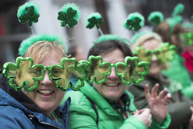 Sharon Keely, left, of Dublin, watches as participants march up Fifth Avenue during the St. Patrick's Day Parade, Saturday, March 16, 2019, in New York. (AP Photo/Mary Altaffer)
